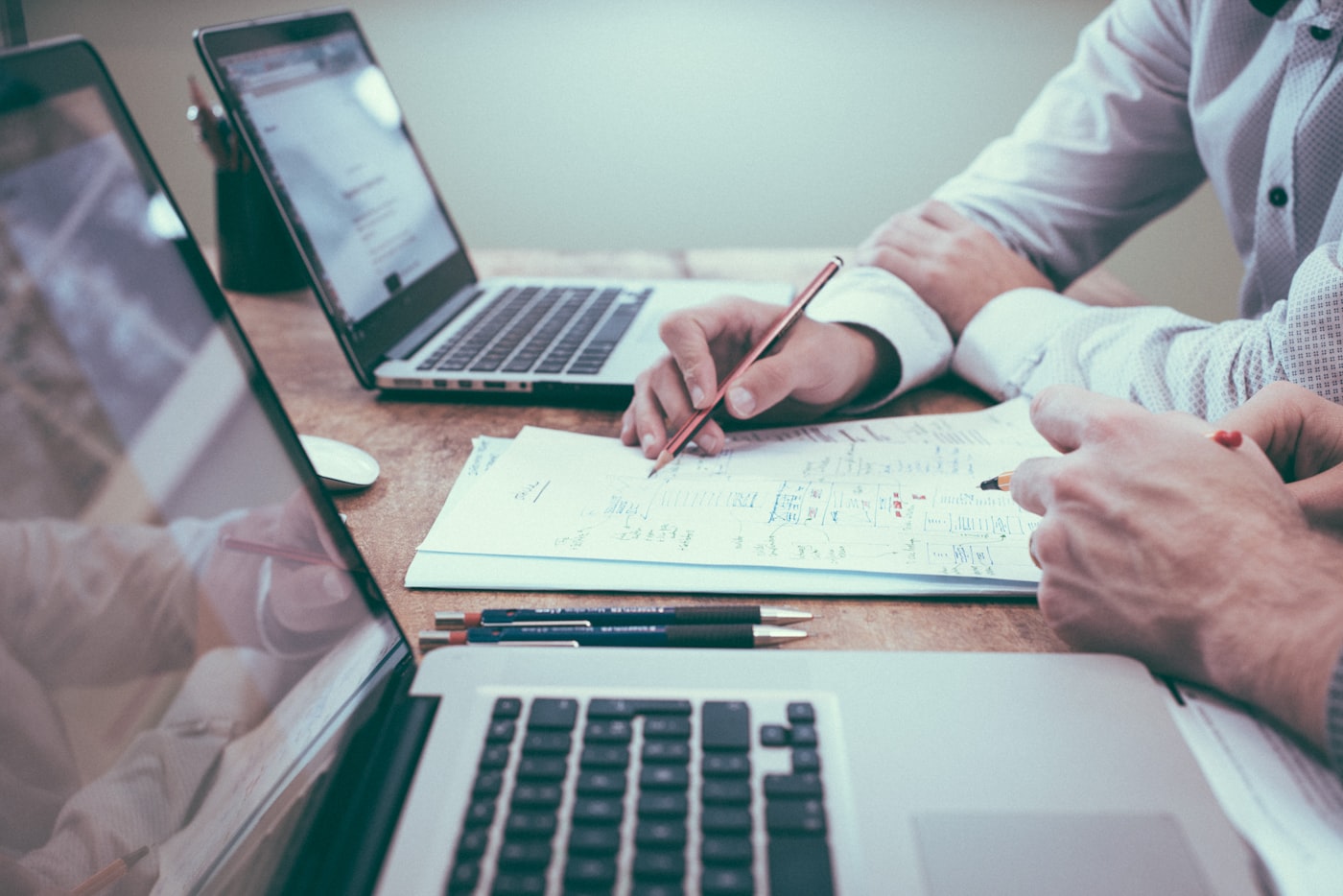 Consultores da Noí analisando documentos de apólices e planilhas de risco
